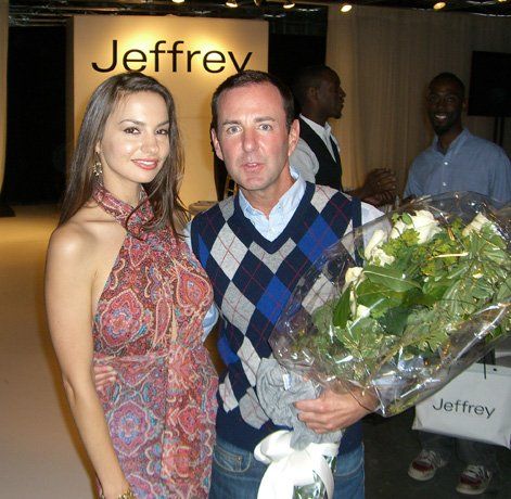 A man and woman pose for a picture in front of a sign that says jeffrey