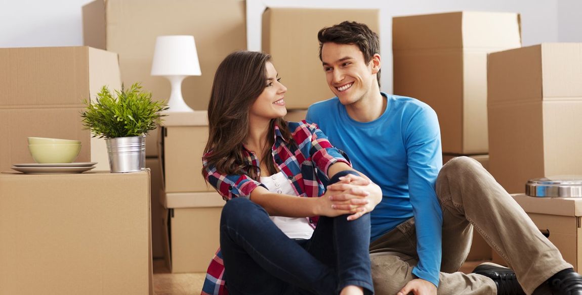 couple sitting between carton boxes