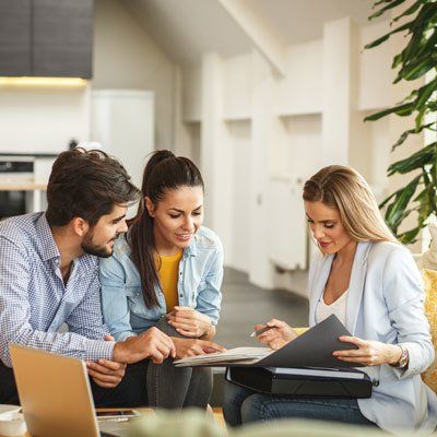 Female Real Estate agent offer home ownership and life insurance to young couple.