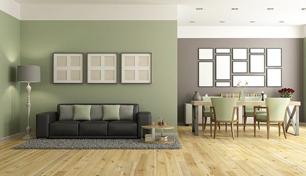 A living room with green walls and a black couch