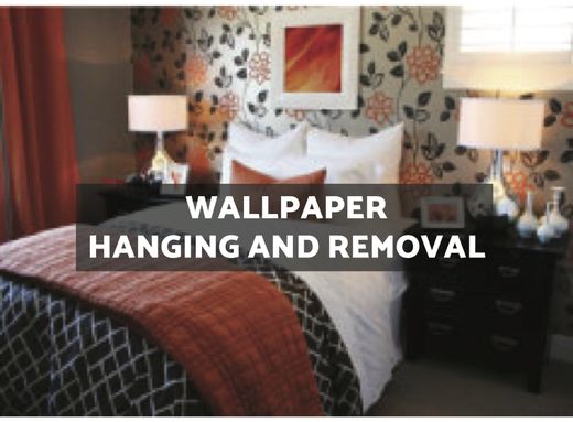 A bedroom with a bed and a sign that says wallpaper hanging and removal