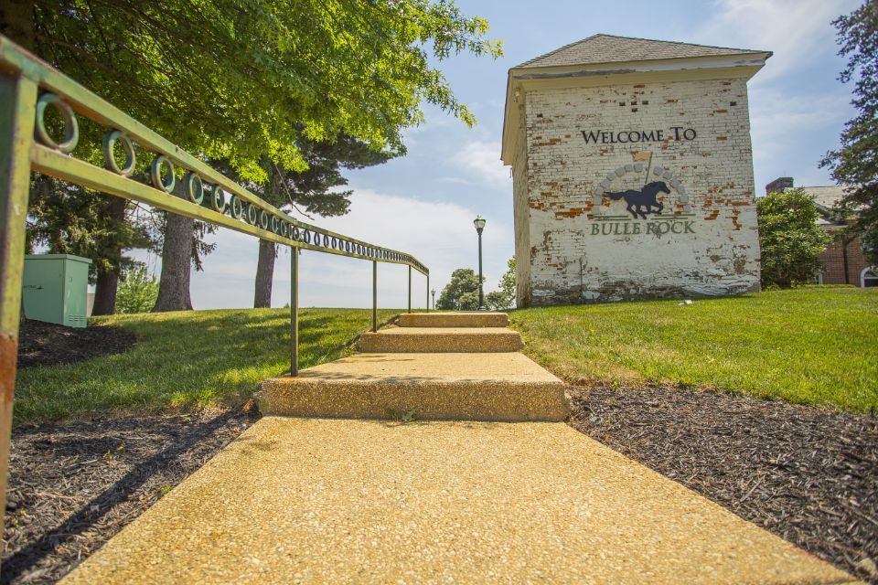 Concrete path and stairs lead to a white building that says 