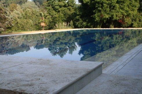 Piscina a sfioro in mosaico e marmo di travertino bianco. Massarosa (LU)_Dir.Lavori