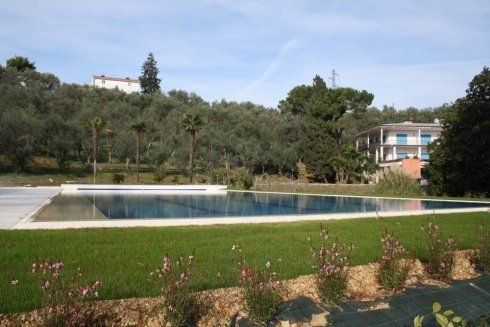 Piscina a sfioro in mosaico e marmo di travertino bianco. Massarosa (LU)_Dir.Lavori