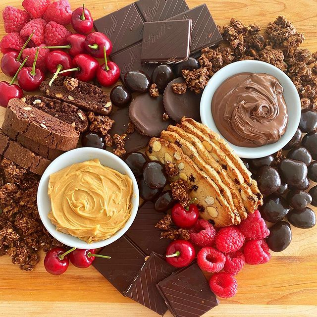 A wooden cutting board filled with a variety of desserts