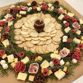 A christmas wreath made of crackers cheese and flowers