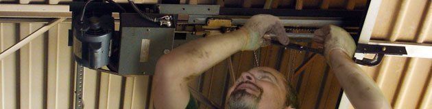 Garage Door Installations — Man Repairing Garage Door in Lomita, CA Garage Door Installations — Man Repairing Garage Door in Lomita, CA