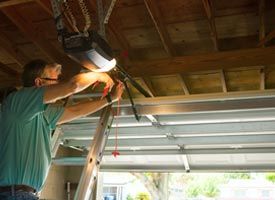 Garage Door Repair — Man Fixing Garage Door in Lomita, CA