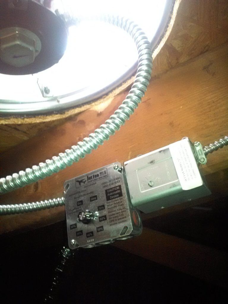 A close up of a ceiling fan with a box attached to it