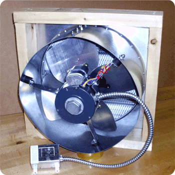 A fan is sitting in a wooden box next to a switch