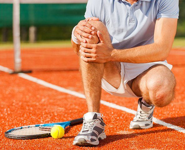 Athlete Holding His Knee — Rose Hill, KS — Rose Hill Chiropractic Athlete Holding His Knee — Rose Hill, KS — Rose Hill Chiropractic