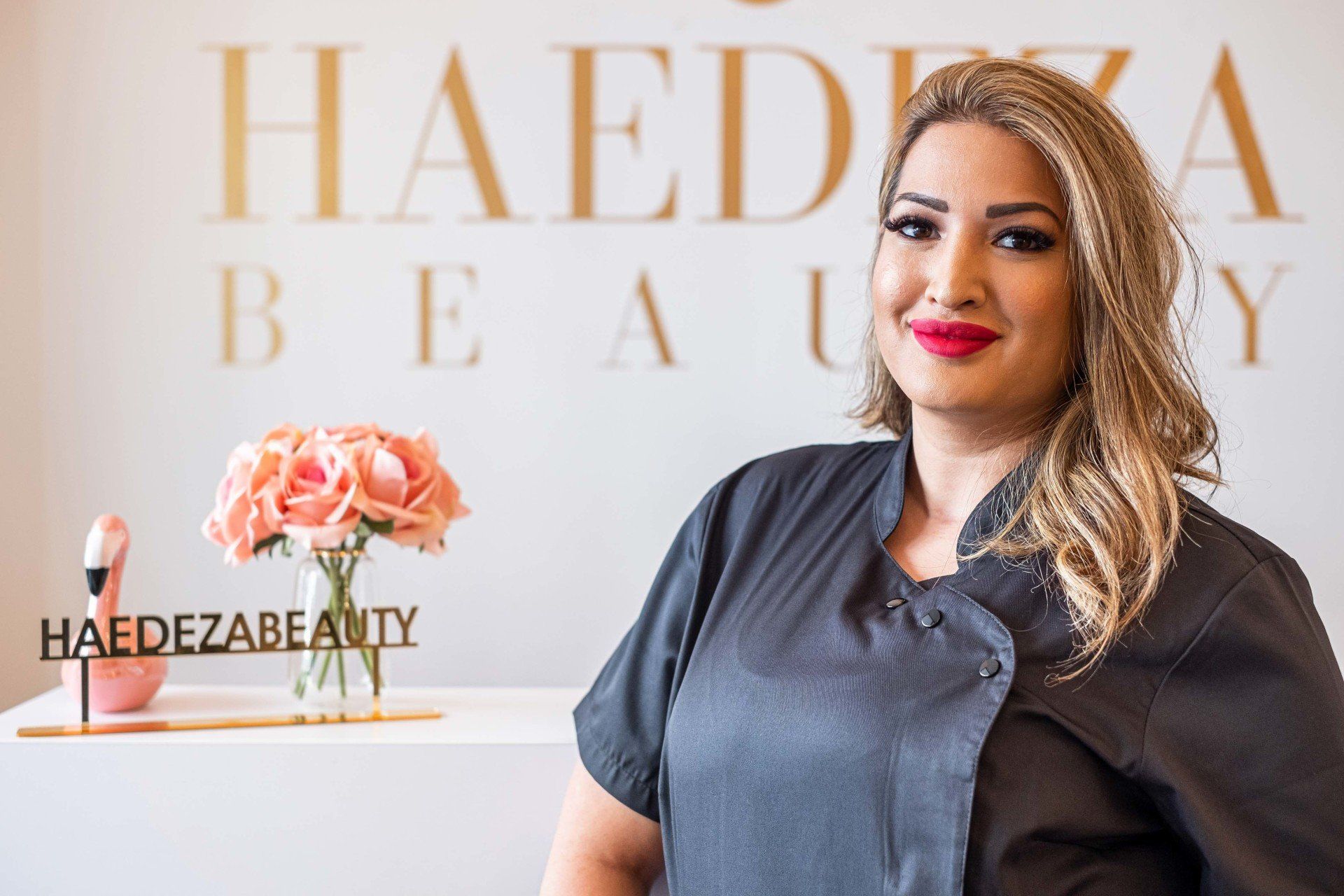 Eine Frau steht vor einem Schild mit der Aufschrift „Haedeza Beauty“