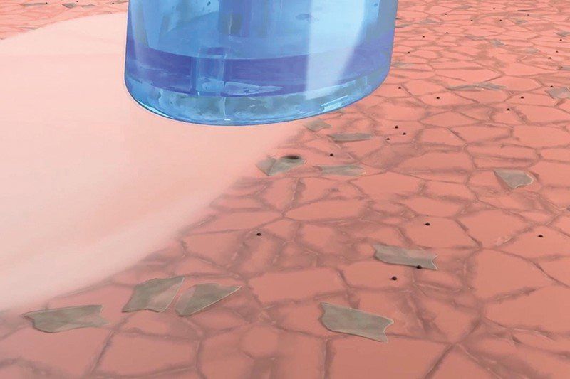 Eine Nahaufnahme einer Wasserflasche auf einer rosa Oberfläche.