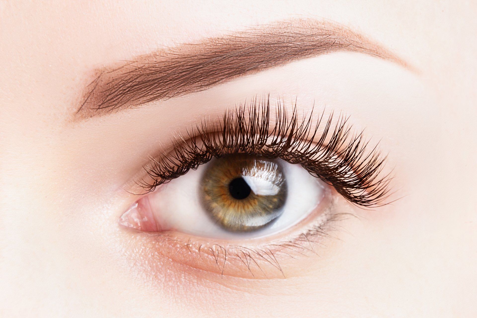 Eine Nahaufnahme des Auges einer Frau mit langen Wimpern.
