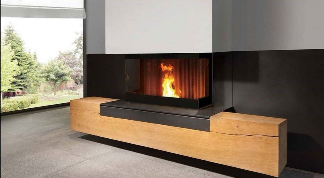 Modernes Wohnzimmer mit eingebautem Kamin, Holzbank und großem Fenster mit Blick ins Grüne
