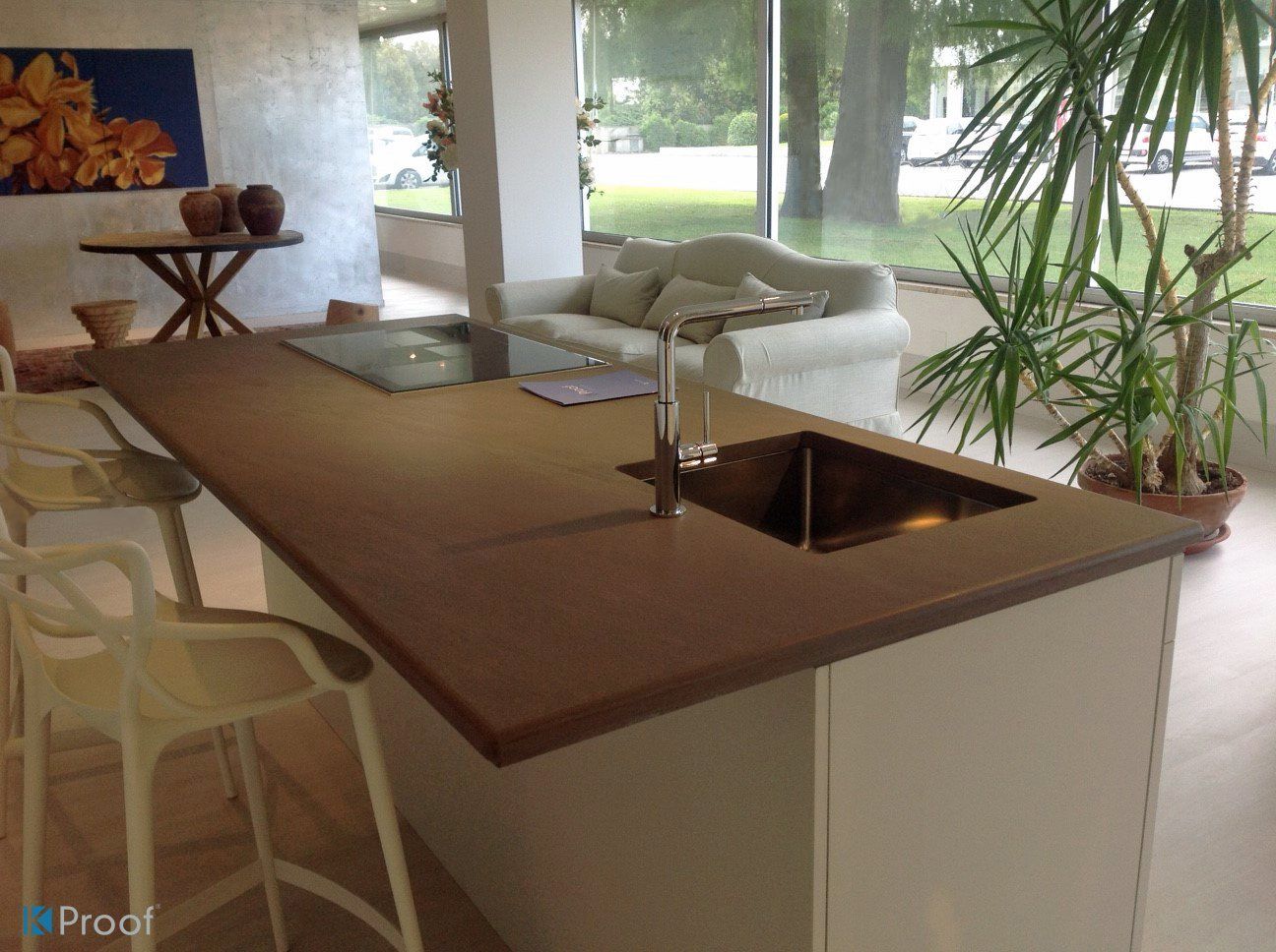Moderne Kücheninsel mit brauner Arbeitsplatte, Spüle und Barhockern in einem hellen, offenen Wohnbereich