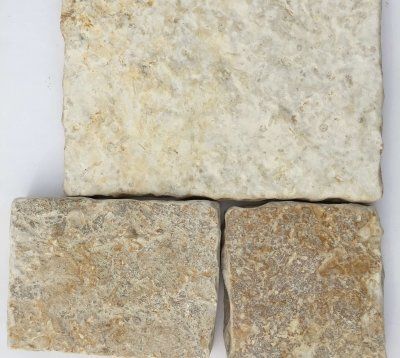 Trzy prostokątne płytki kamienne w różnych odcieniach beżu i brązu, o szorstkiej, teksturowanej powierzchni.