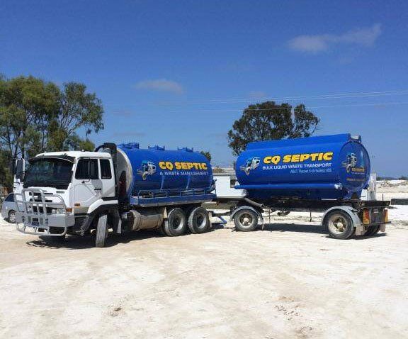 Two co septic trucks are parked next to each other