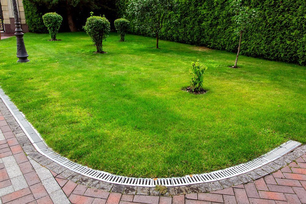 Curved Iron Grid Drainage System in the Backyard — Tampa, FL — J & M Lawn Service and More LLC