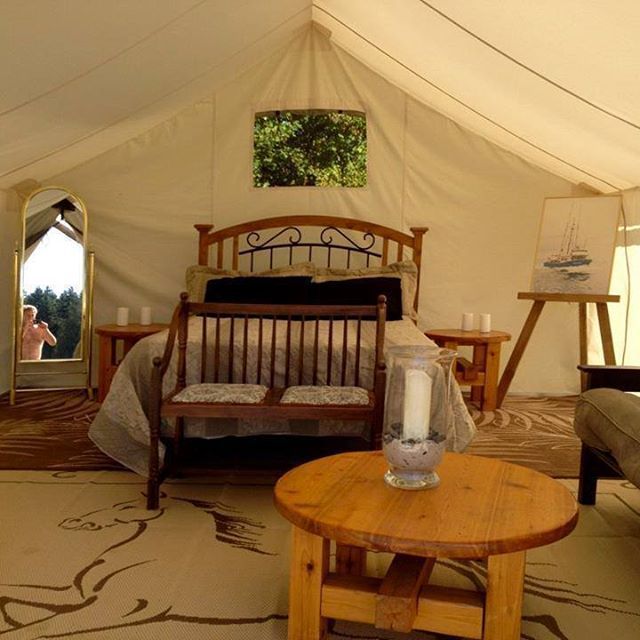 A room with a bed and a table with a candle on it