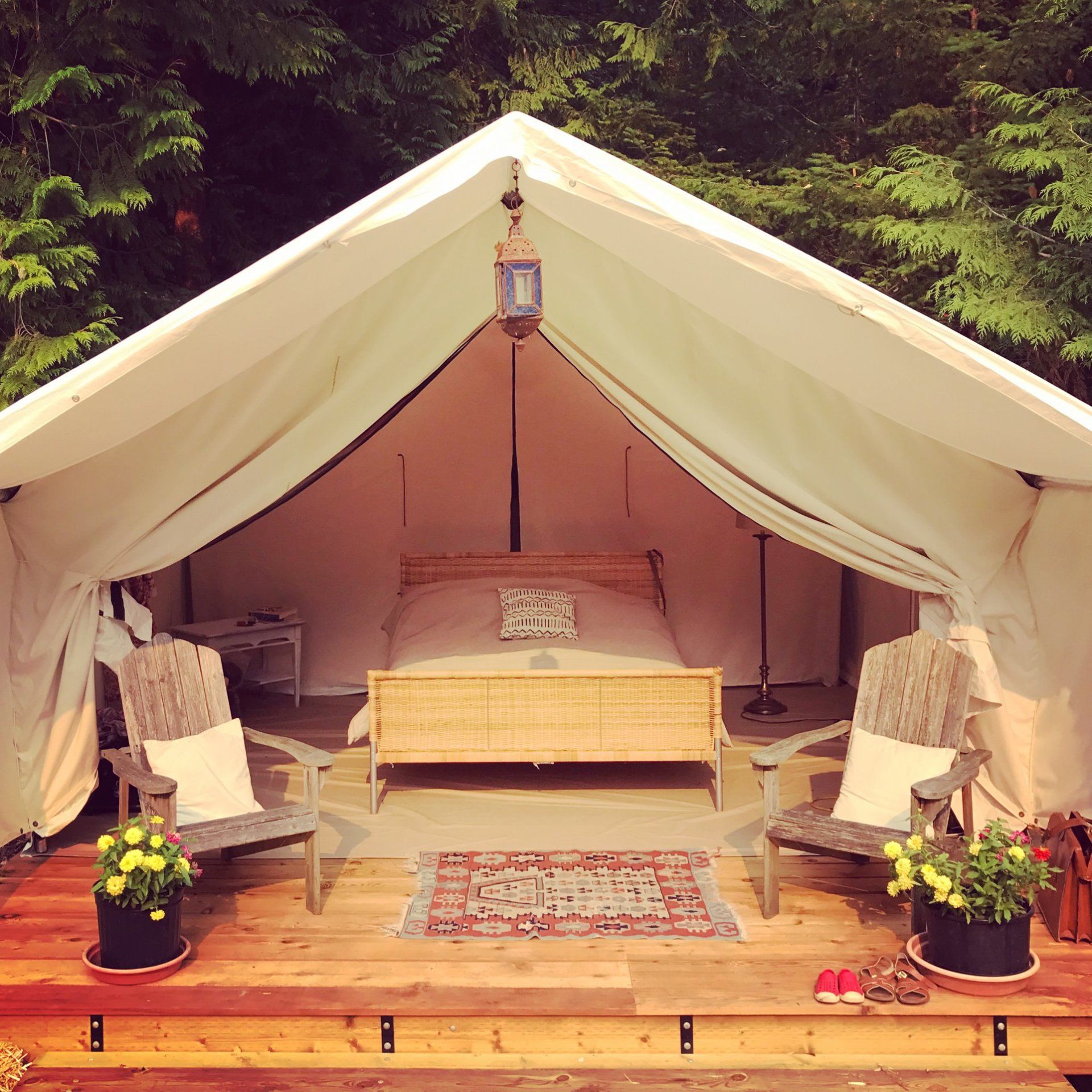 A tent with a bed and chairs inside of it