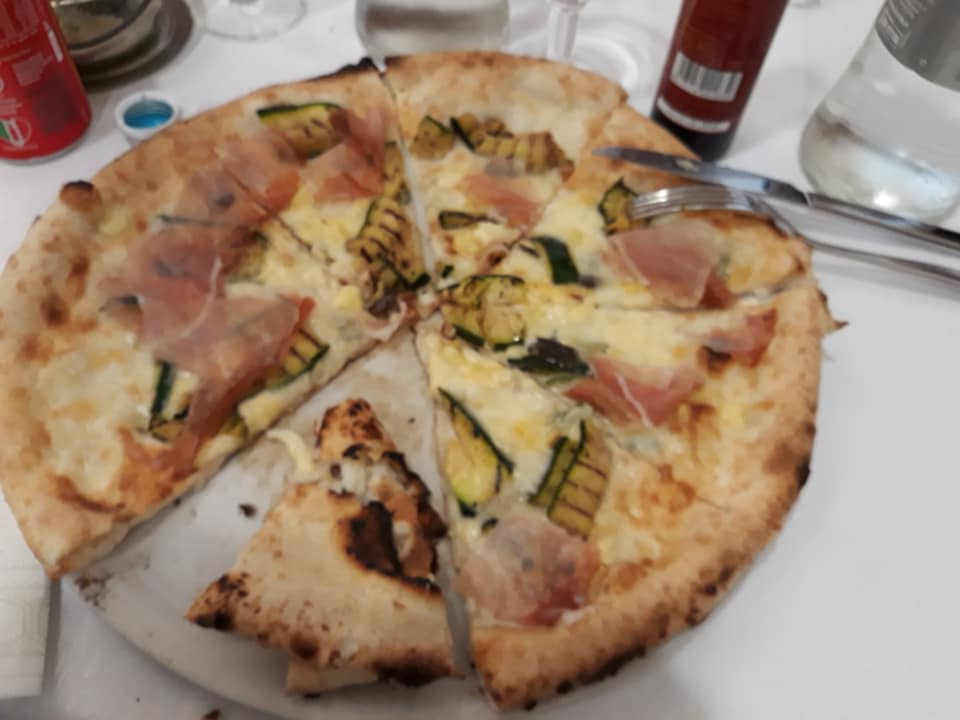Pizza con mozzarella, pomodoro, prosciutto crudo e verdure grigliate