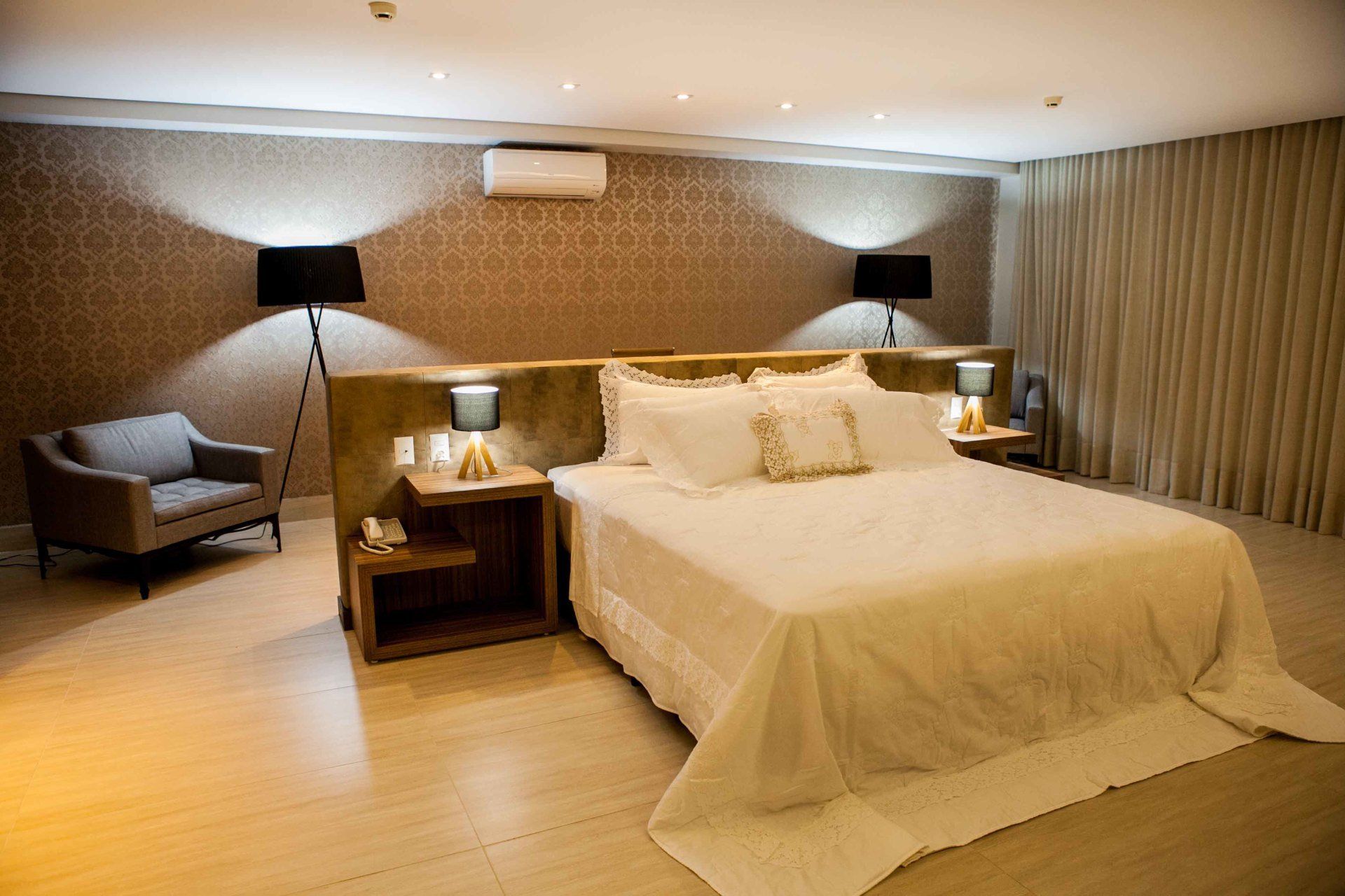 Há uma cama grande no meio do quarto.