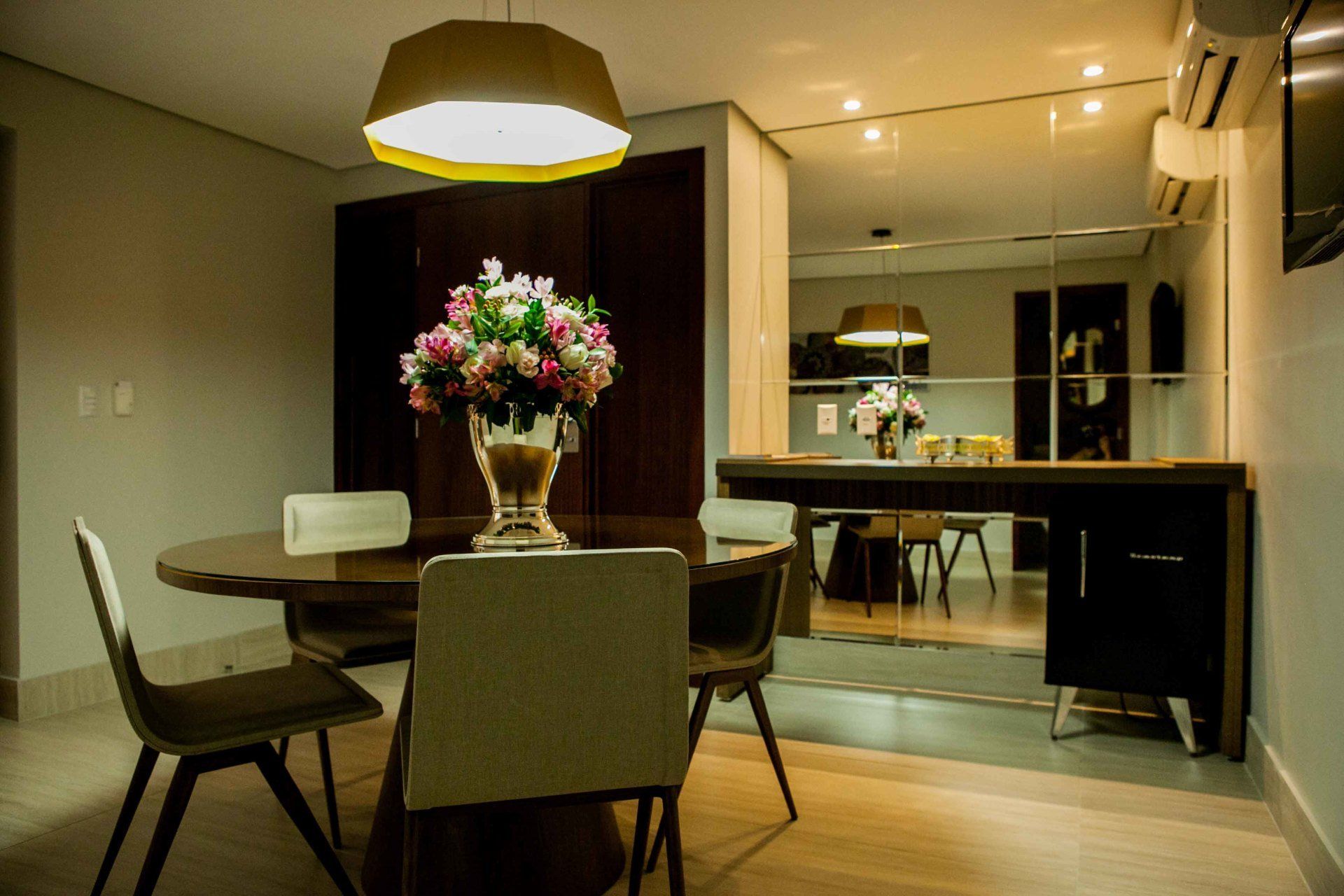Uma sala de jantar com uma mesa e cadeiras e um vaso de flores