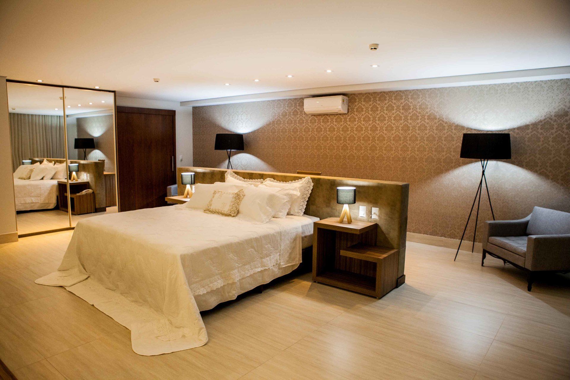 Há uma cama grande no meio do quarto.