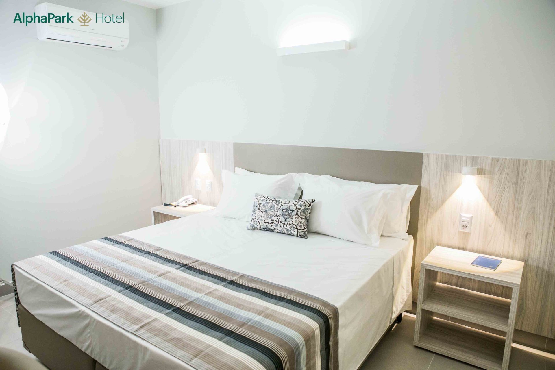 Um quarto de hotel com uma cama king size e duas mesas de cabeceira.