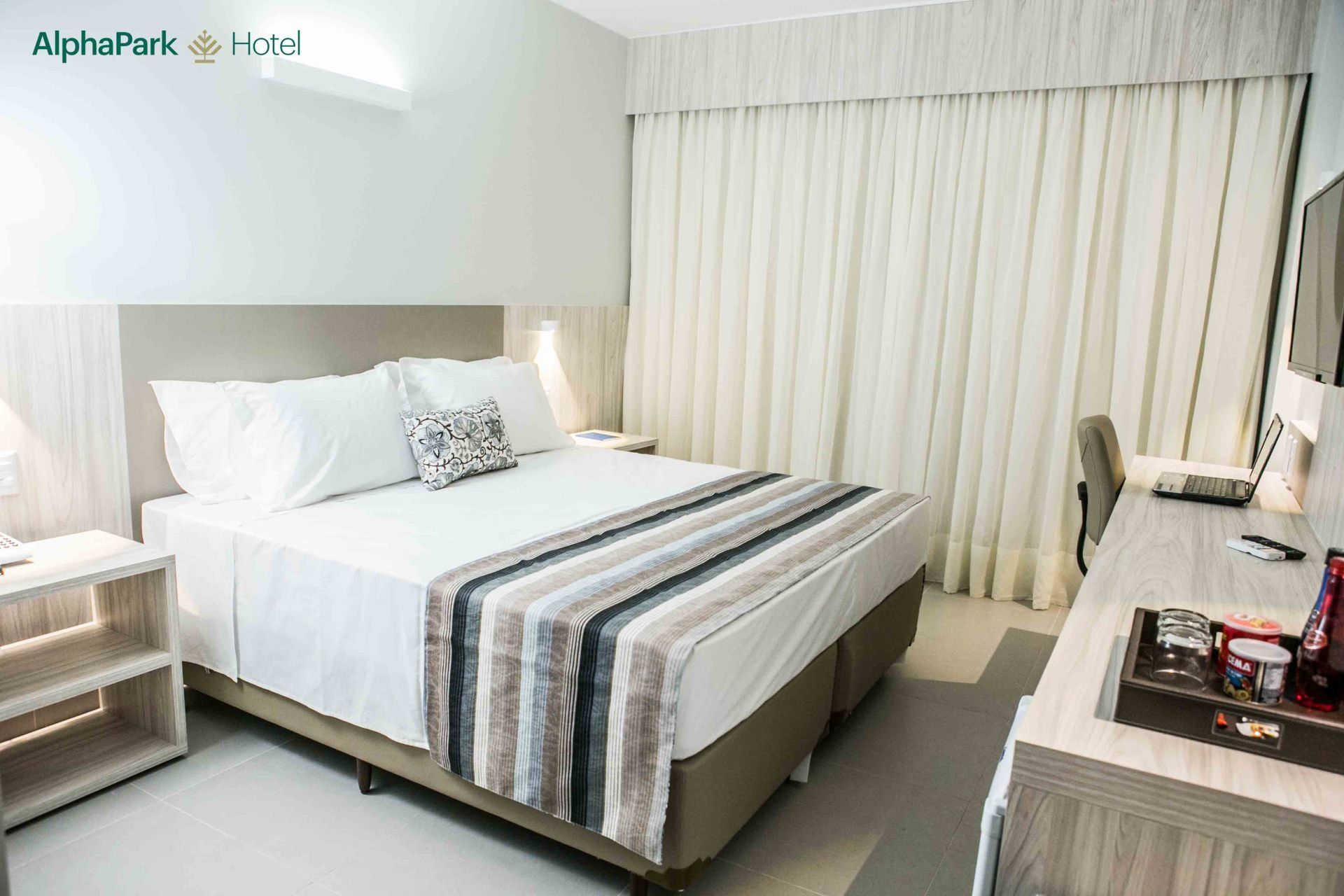 Um quarto de hotel com uma cama king size e uma escrivaninha.