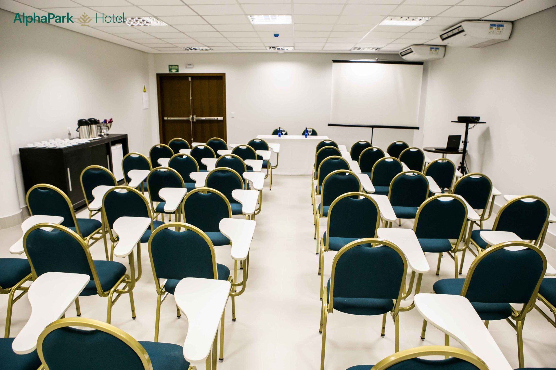 Uma sala de conferências com fileiras de cadeiras e mesas