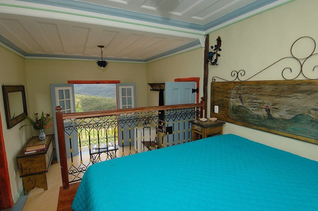 Um quarto com uma cama azul e uma varanda