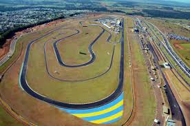 Uma vista aérea de uma pista de corrida com uma faixa azul e amarela na lateral.