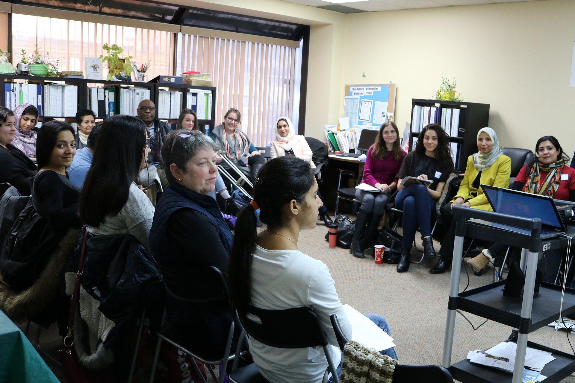A group of women are sitting in a circle in a room.