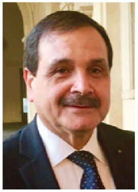 A man with a mustache is wearing a suit and tie.