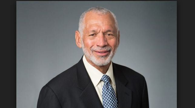 A man in a suit and tie is smiling for the camera.