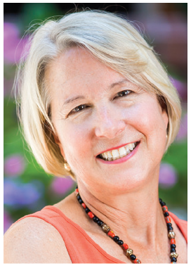 A close up of a woman wearing a necklace and smiling.