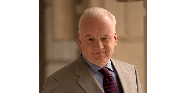 A man in a suit and tie is looking at the camera.
