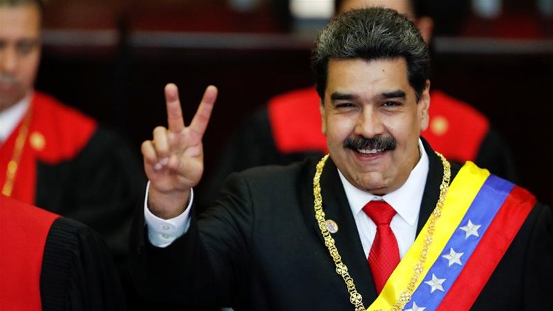A man in a suit and tie is giving a peace sign