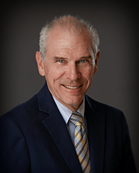 A man in a suit and tie is smiling for the camera.
