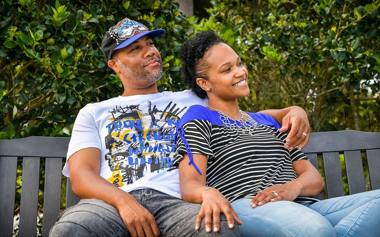 A man and a woman are sitting on a park bench.