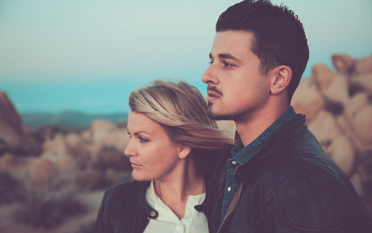 A man and a woman are standing next to each other in the desert.