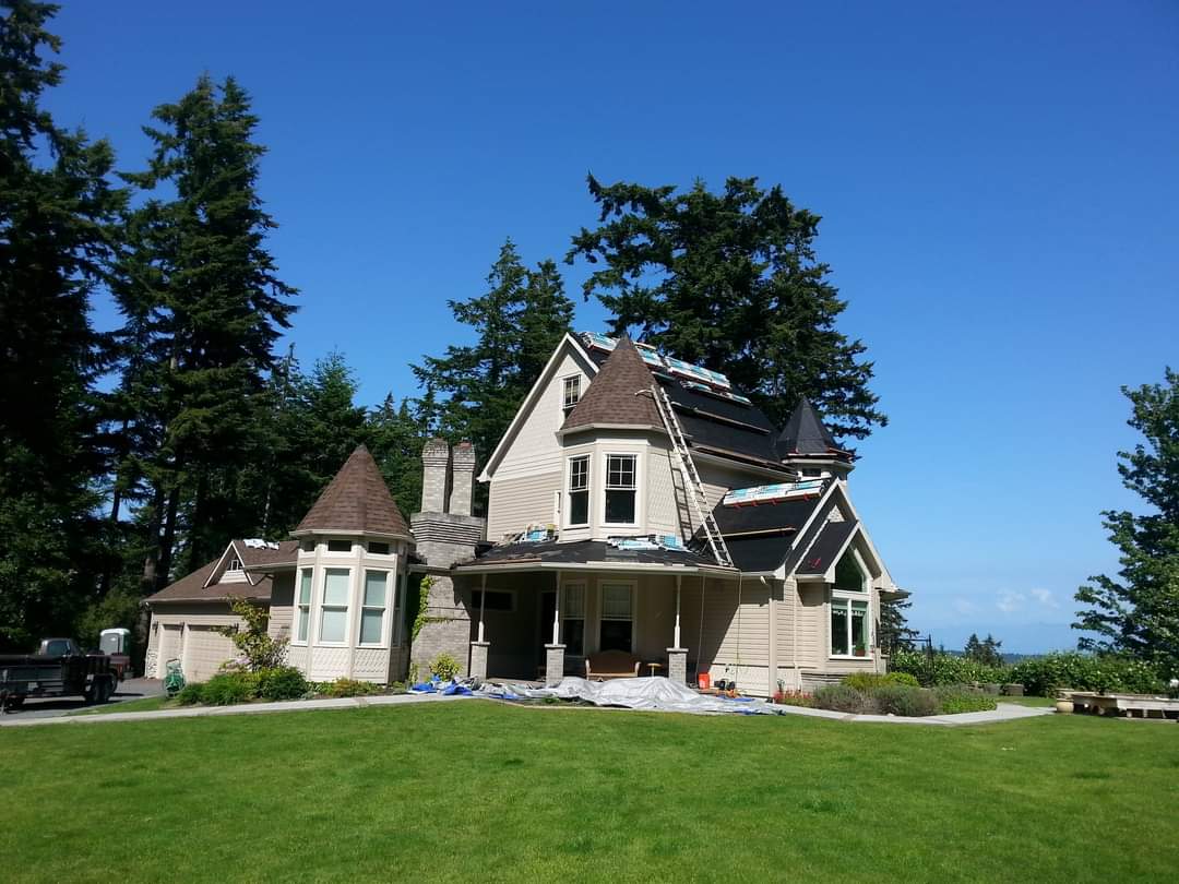 A large house sits in the middle of a lush green field