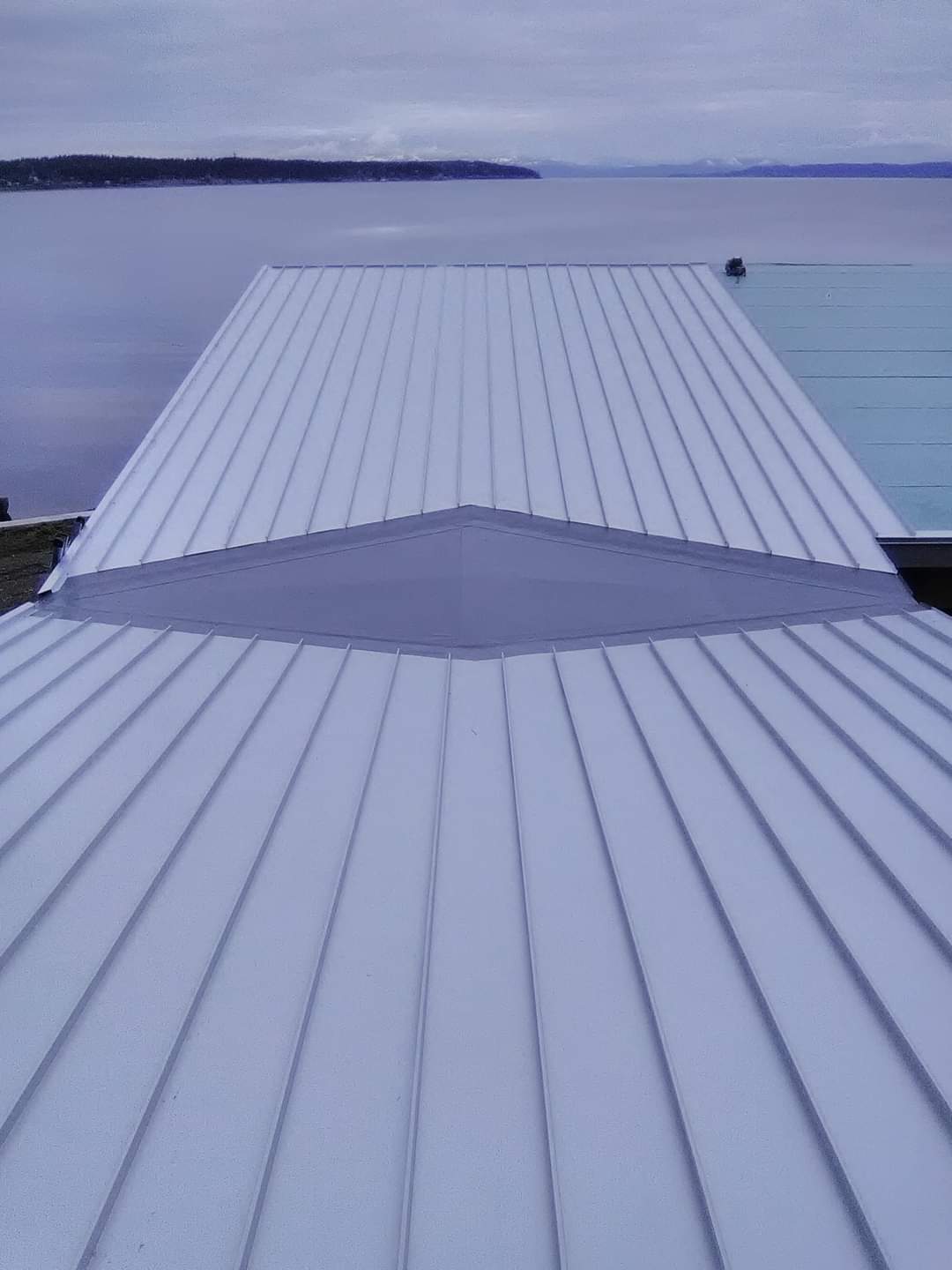 A dock with a white roof overlooking a body of water