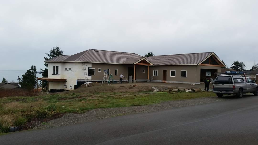 A large house under construction with a truck parked in front of it.