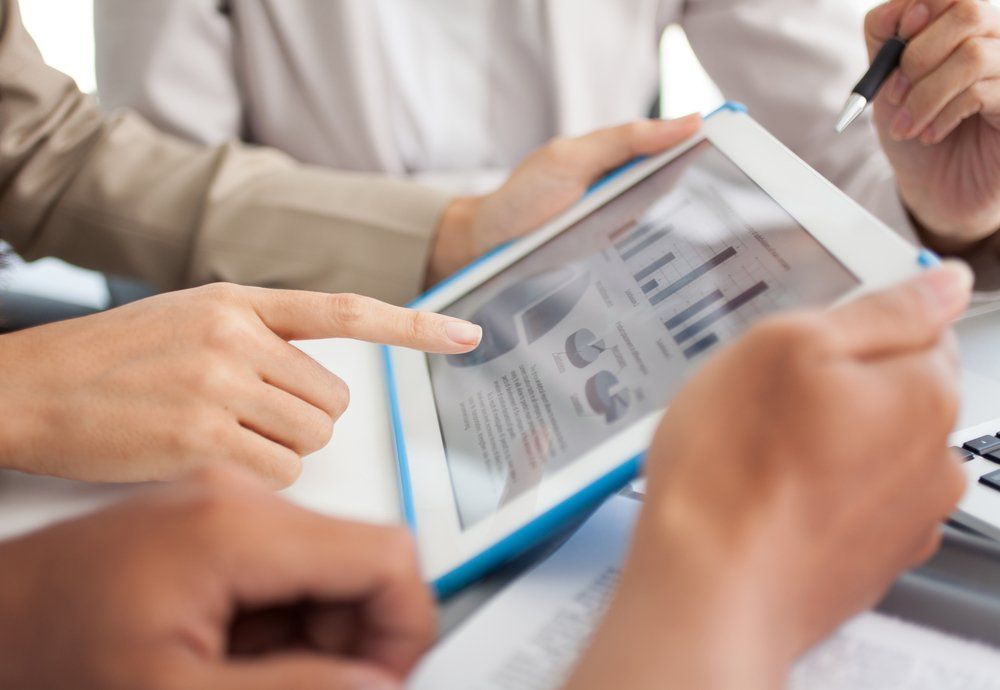 A person is pointing at a graph on a tablet