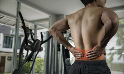 A Man on a Gym Having Back Pain — Sunnyside, WA — Yakima Valley Chiropractic Center A Man on a Gym Having Back Pain — Sunnyside, WA — Yakima Valley Chiropractic Center