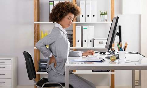 Woman Having A Backpain While Working — Sunnyside, WA — Yakima Valley Chiropractic Center Woman Having A Backpain While Working — Sunnyside, WA — Yakima Valley Chiropractic Center