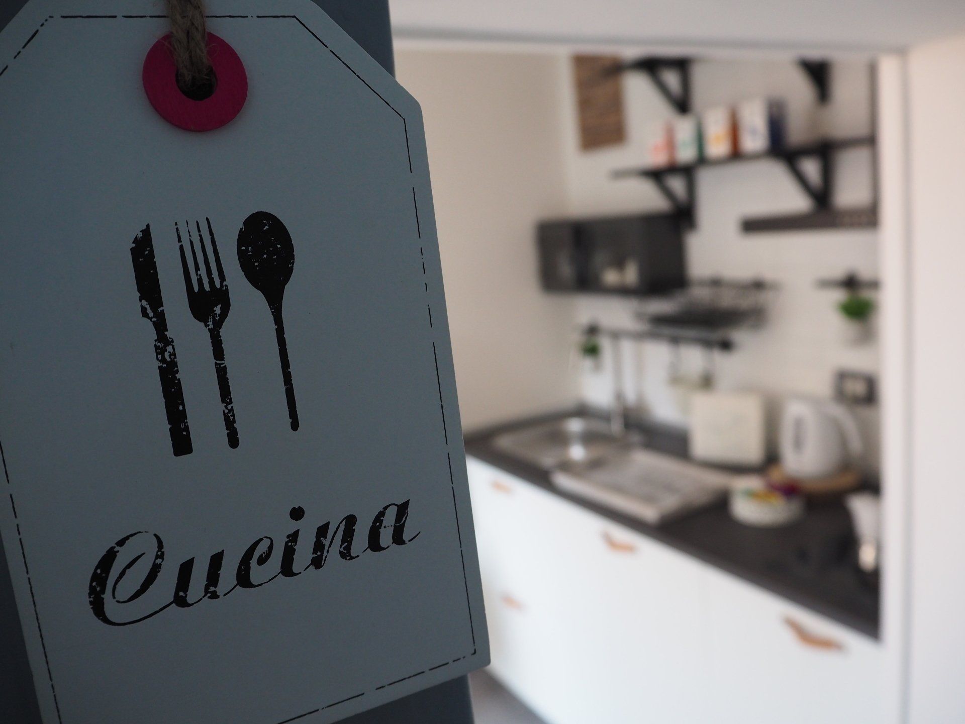 Cucina attrezzata in appartamento a Bergamo, con bollitore, piano a induzione e suppelletili.